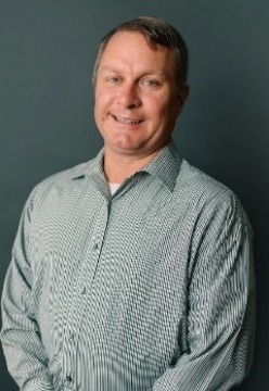 image of man smiling and wearing a dress shirt.